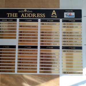 Large black and gold housing society name board for The Address A Wing with floor-wise resident list.