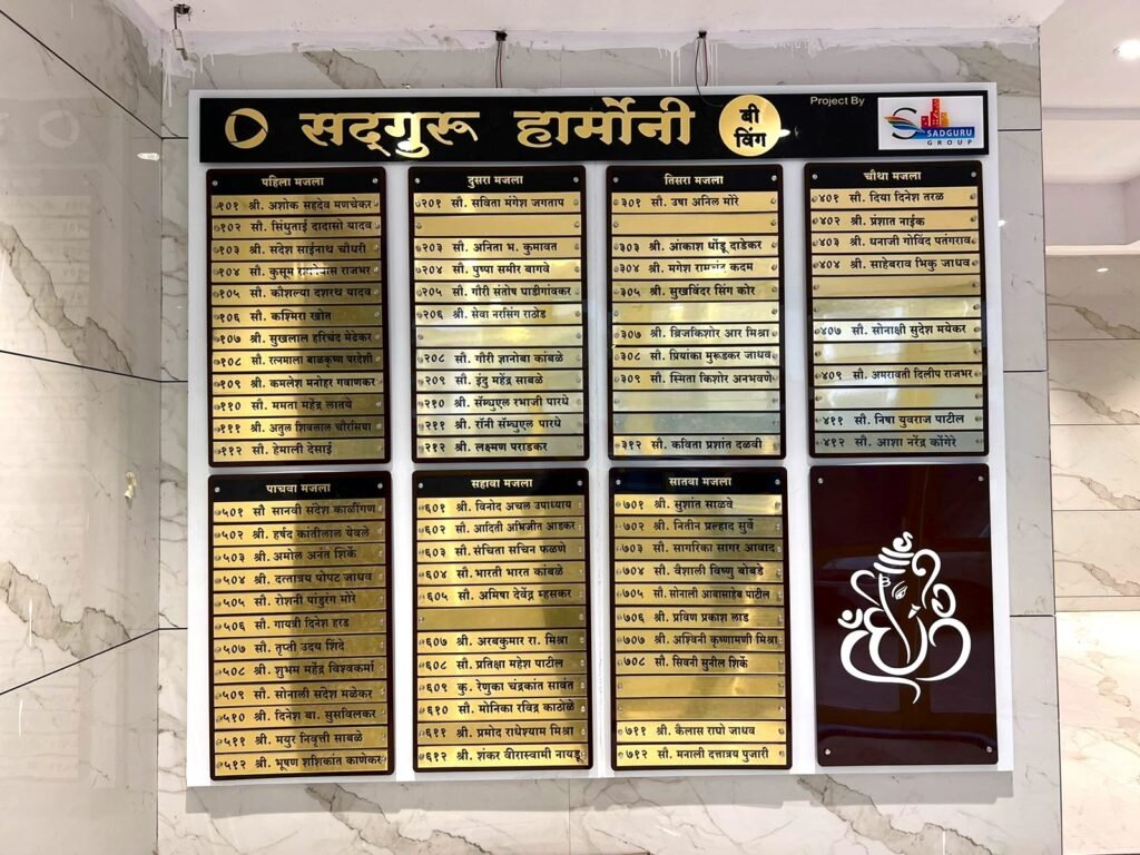 Marathi housing society name board for Sadguru Harmony B Wing with gold text on black background.