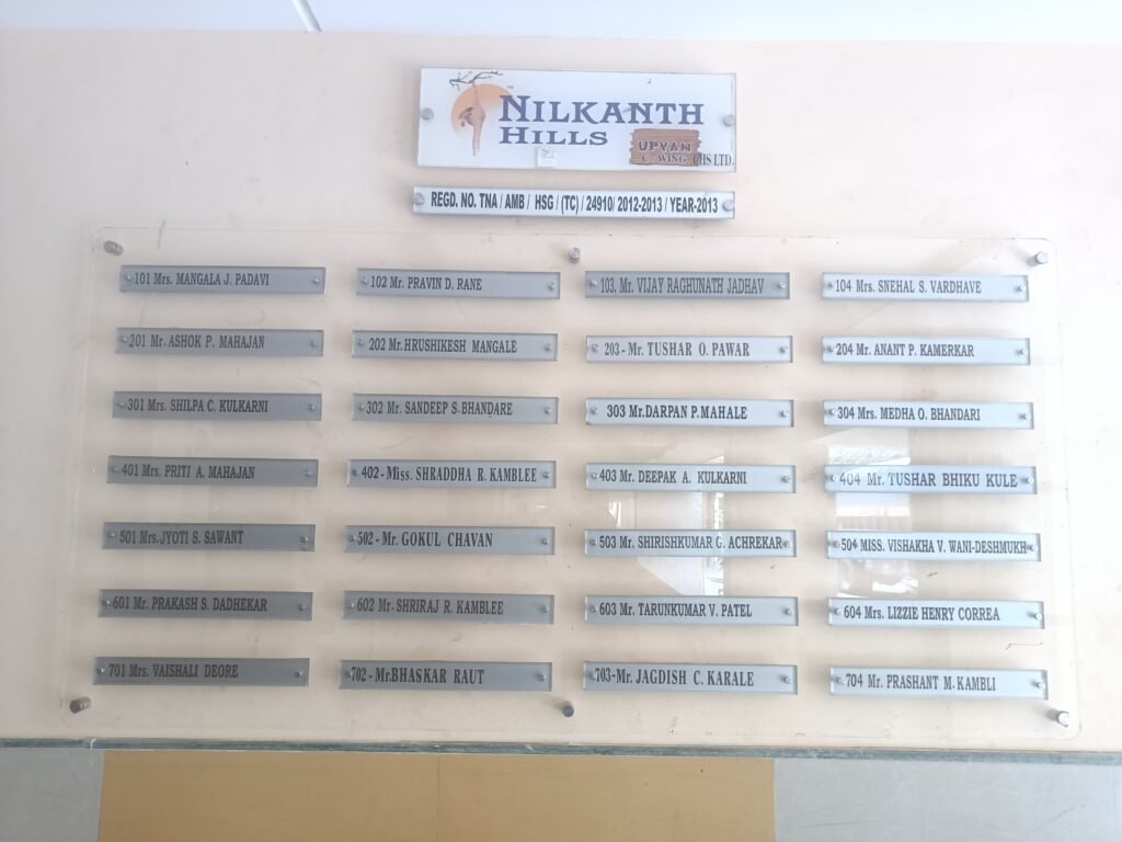 Acrylic housing society name board for Nilkanth Hills C-Wing with resident list and standoff mounts.